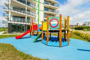 un parque infantil frente a un edificio de apartamentos en Apartament Westin House 303, en Kołobrzeg