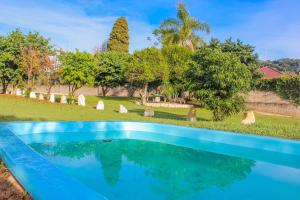 una piscina en un patio con árboles y un campo en Hotel Parque en Nova Petrópolis