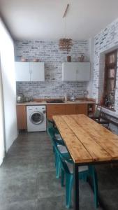 cocina con mesa de madera y sillas verdes en Alex b&b, en Kapan