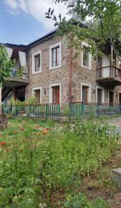 un antiguo edificio de ladrillo con un patio con flores en Alex b&b, en Kapan