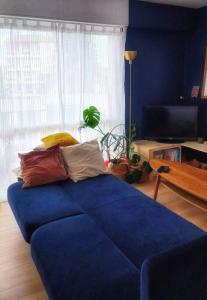 ein blaues Sofa mit Kissen darauf im Wohnzimmer in der Unterkunft Magnifique T2 à Bordeaux in Bordeaux