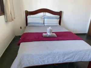 a bed with a bottle of soap on top of it at Hope Hostel Guarapari in Guarapari