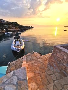 a boat is docked in the water at sunset at Apartments Amfora in Gdinj