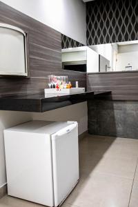 a kitchen with a white refrigerator and a counter at Link Motel in Cabedelo