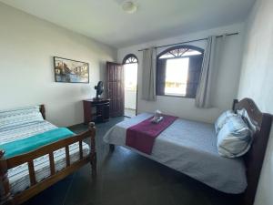 um quarto com 2 camas e uma janela em Hope Hostel Guarapari em Guarapari