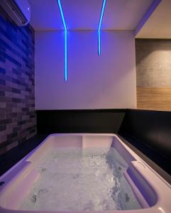 a large bath tub with blue lights in a room at Link Motel in Cabedelo