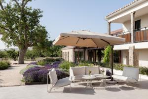 un patio con mesa, sillas y sombrilla en Quinta San Francisco en Castrojeriz