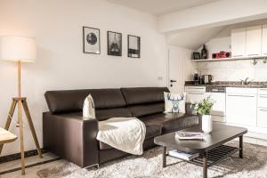 a living room with a leather couch and a table at VIEW4TWO / Chalet-Apartment Zillertal in Hart im Zillertal