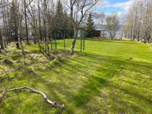 un campo de césped con árboles y una valla en Near Golden Circle-10 sleeps, en Selfoss