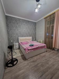 a bedroom with a bed with a pink comforter at Magdan house in Tskaltubo