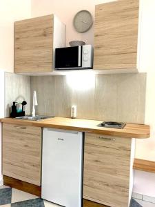 La cuisine est équipée d'un réfrigérateur blanc et d'un four micro-ondes. dans l'établissement Hippocampus, à Varna