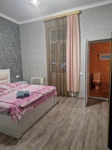 a bedroom with a bed with a pink comforter at Magdan house in Tskaltubo