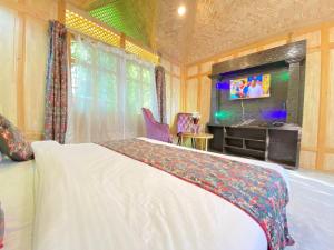a bedroom with a bed and a tv in a room at Luxury Egypt Group of House Boat in Srinagar