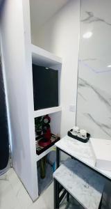 um quarto branco com uma televisão e uma mesa em Spazen30 em Nîmes