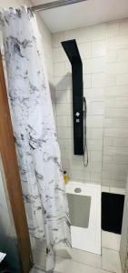uma cortina de chuveiro na casa de banho com banheira em Spazen30 em Nîmes
