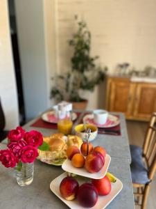 un tavolo con piatti di frutta e fiori di Le gîte du port canal a Moissac