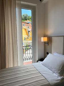 a bedroom with a bed and a large window at Albergo Degli Amici in Monterosso al Mare
