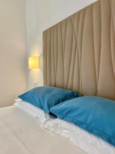 un letto con 2 cuscini blu e una testiera del letto di Albergo Degli Amici a Monterosso al Mare