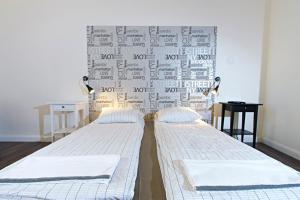 2 camas en una habitación con una pared cubierta de recibos en Central 5 Guest House, en Budapest