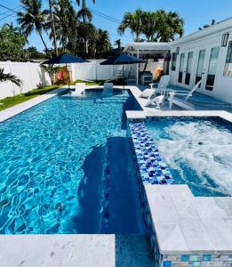 a swimming pool with blue water in front of a house at Designer Pool & Family Dream Home in Hollywood
