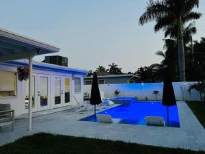 a villa with a swimming pool in front of a house at Designer Pool & Family Dream Home in Hollywood
