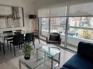 un soggiorno con tavolo e sedie in vetro di MLA apartments - Reducto 360 a Lima
