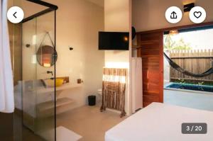 a bathroom with a shower with a glass door at Magaral Corais Chalé in Pôrto de Pedras