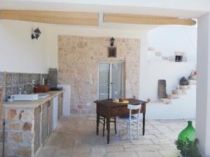 een keuken met een houten tafel in een kamer bij Holiday Home Trullo Antico in Ostuni