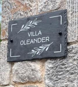 un panneau sur le côté d'un mur de pierre dans l'établissement Villa Oleander Agios Nikolaos Loutra Edipsou, à Loutra Edipsou