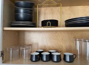 a shelf with black bowls and other dishes on it at Stylish 1 Bedroom Apt - Brooklyn by train station in Brooklyn