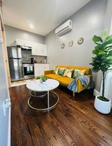 a living room with a yellow couch and a table at Stylish 1 Bedroom Apt - Brooklyn by train station in Brooklyn