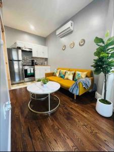 a living room with a yellow couch and a table at Stylish 1 Bedroom Apt - Brooklyn by train station in Brooklyn +11 photos