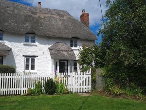 uma velha casa branca com uma cerca branca em Furneaux Hatch em Kingsbridge
