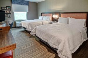 a hotel room with two beds and a television at Hampton Inn & Suites Culpeper in Culpeper