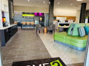 a lobby with a green couch and a kitchen at Home2 Suites By Hilton Edinburg in Edinburg