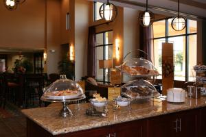un buffet con tre vassoi di cibo su un bancone di Hampton Inn & Suites West Point a West Point