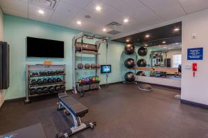 einen Fitnessraum mit einem Fitnessraum mit Laufband und Gewichten in der Unterkunft TRU By Hilton Clarksville in Clarksville