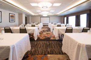 a conference room with white tables and chairs and a screen at Hampton Inn & Suites Albuquerque North/I-25 in Albuquerque