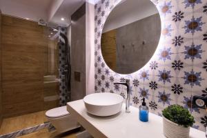 a bathroom with a sink and a mirror at Elysian Rose Residence in Rethymno