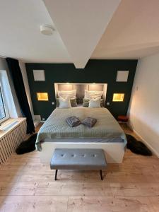 BäkにあるAppartement fliegender Hirschの緑の壁のベッドルーム1室(大型ベッド1台付)