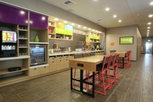 a restaurant with a bar with red chairs and a table at Home2 Suites By Hilton Nampa in Nampa