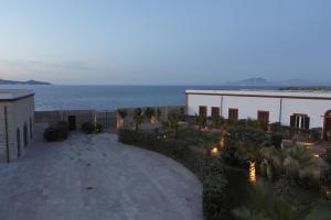 a view of a building and the ocean at dusk at I Pretti Resort in Favignana