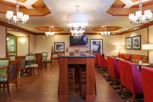 a restaurant with tables and chairs and a bar at Hampton Inn Elkton in Elkton