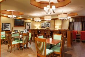 un restaurant avec des tables et des chaises ainsi qu'un bar dans l'établissement Hampton Inn Elkton, à Elkton