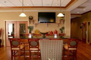 a dining room with a table and chairs and a flat screen tv at Hampton Inn Mountain Home in Mountain Home