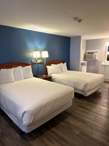 a hotel room with two beds and a blue wall at Trade Winds on the Bay in Rockland