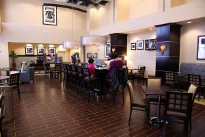a dining room with people sitting at tables in a restaurant at Hampton Inn & Suites Carlsbad in Carlsbad