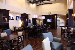 a restaurant with tables and chairs and a clock at Hampton Inn & Suites Carlsbad in Carlsbad