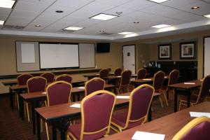 una clase con mesas, sillas y una pantalla blanca en Hampton Inn and Suites Peru en Peru