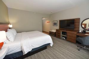 a hotel room with a bed and a flat screen tv at Hampton Inn Richwood Cincinnati South, KY in Richwood